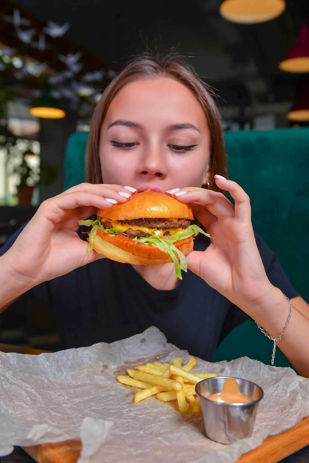 Woman eating burger and fries smiling