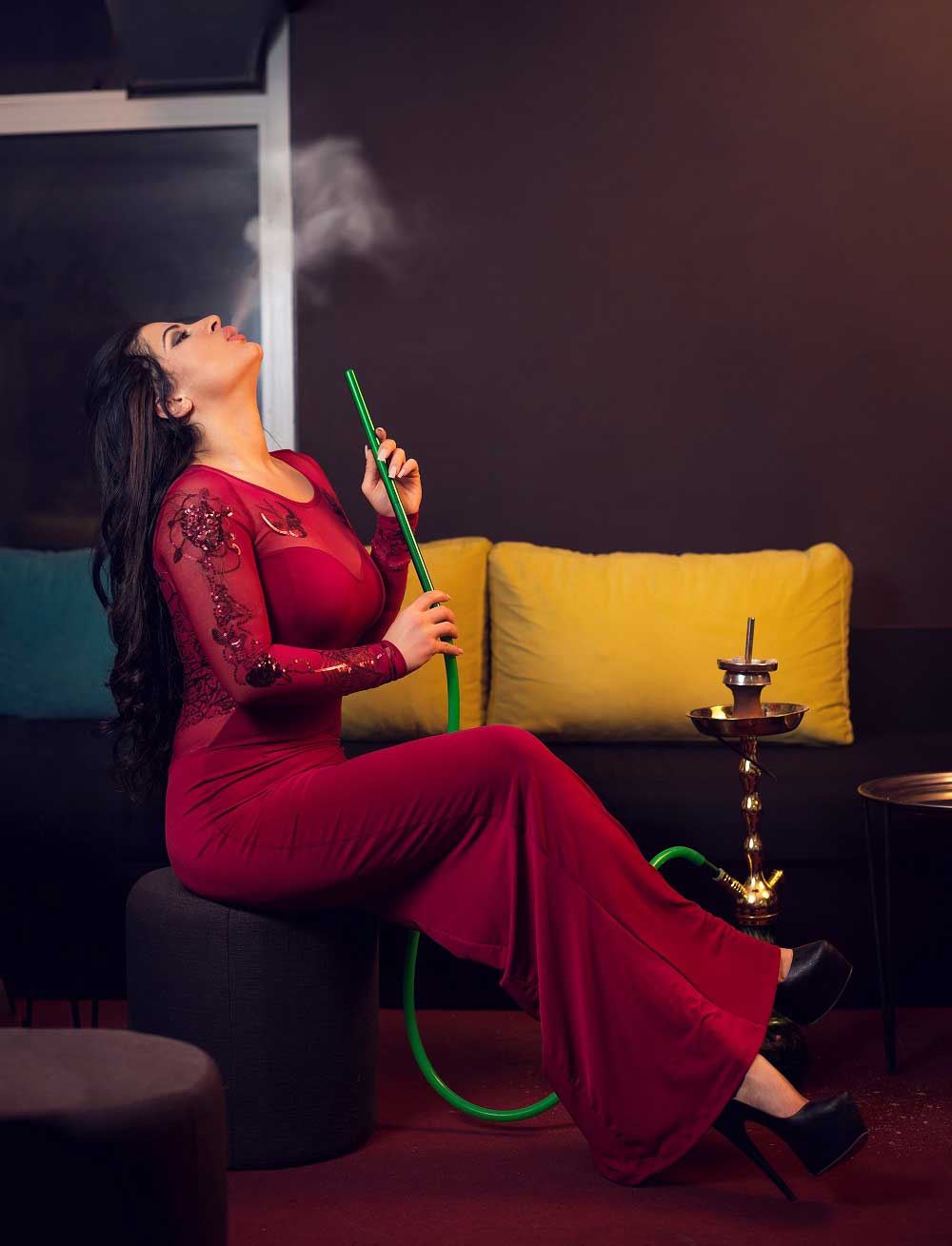 Young attractive gir smoking narghile hookah in bar