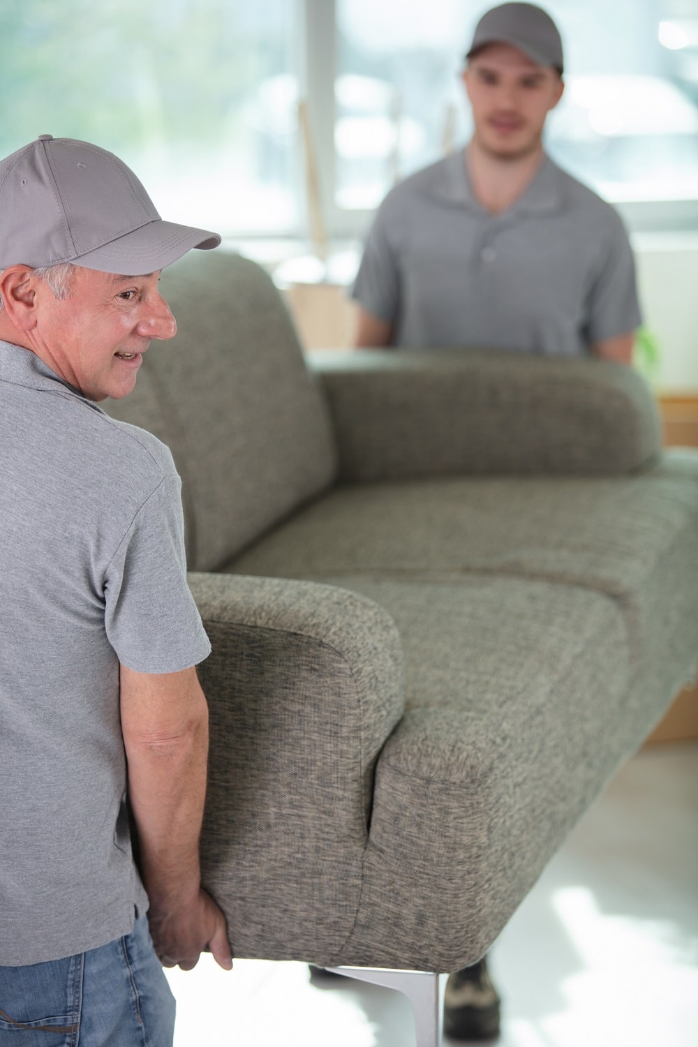 male movers placing sofa in a home