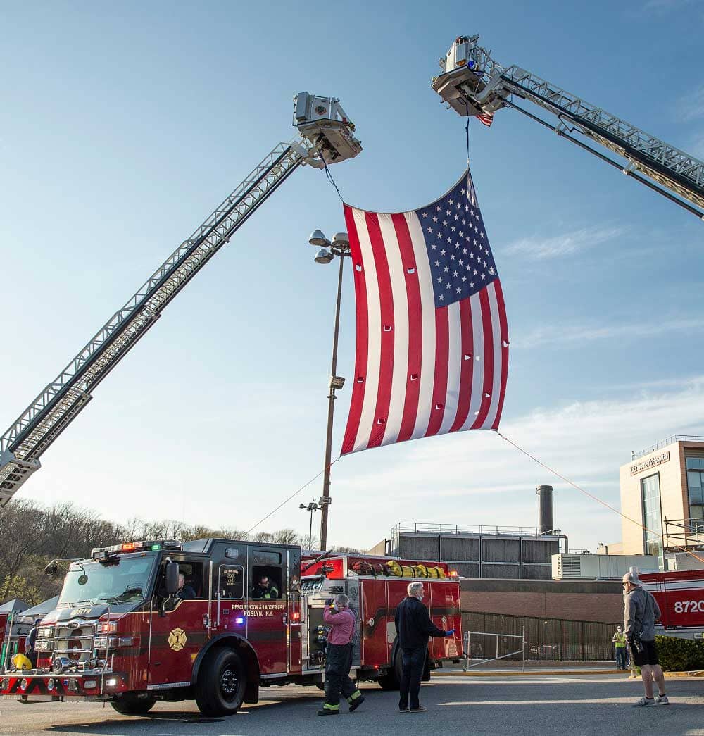 Firefighters raise huge American flag during Nassau County first responders line up to salute front lines heroes of COVID 19 pandemic at North Shore University Hospital 1